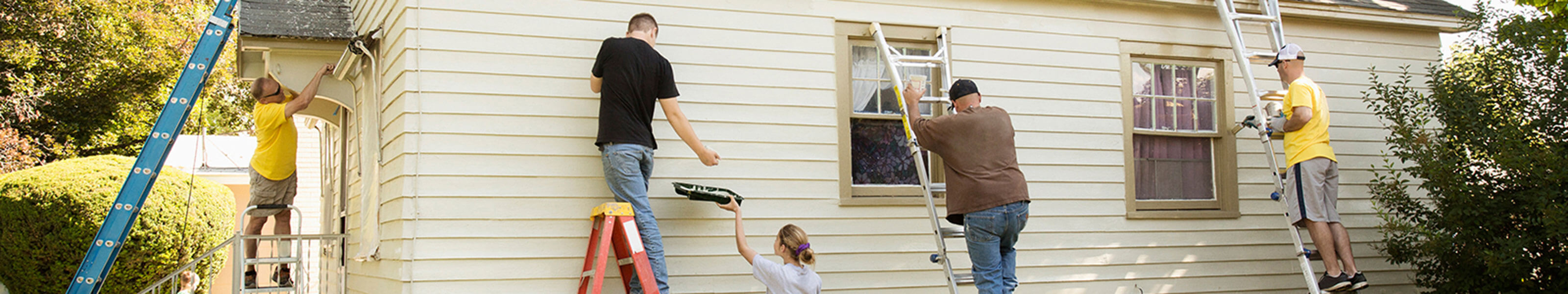 A group of volunteers are painting a house.