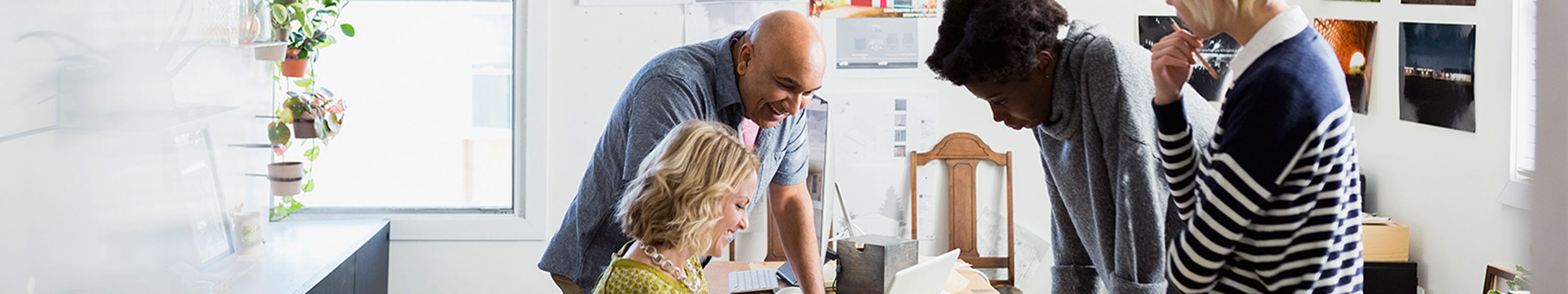 A multi-ethnic group of people are working together on a project in an office.