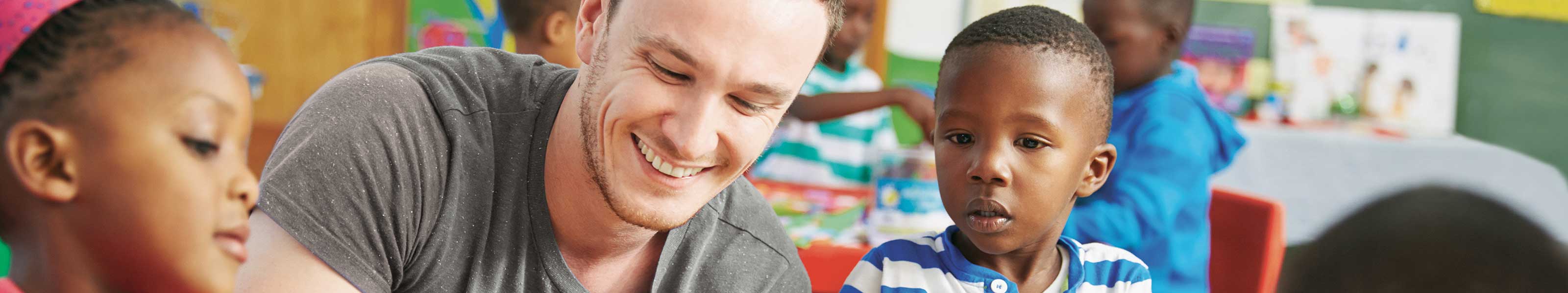 A male volunteer is working with two young children.