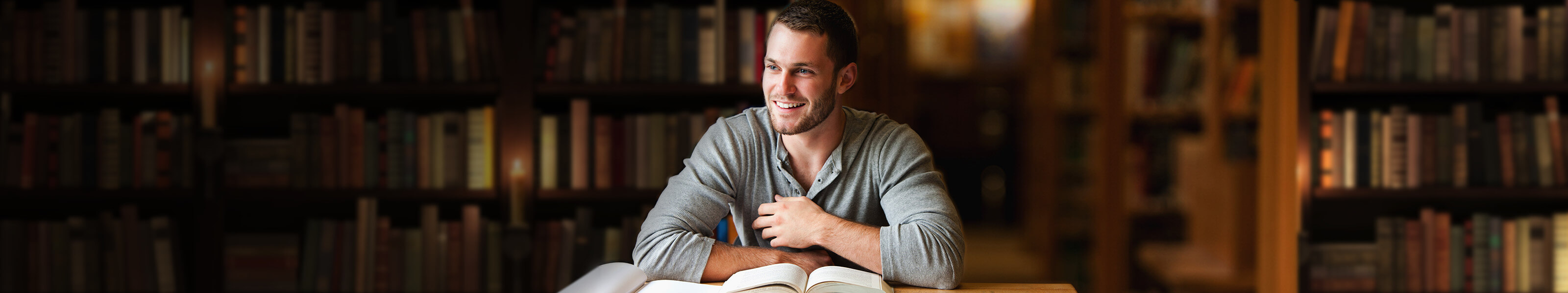 Young male adult sitting in library.