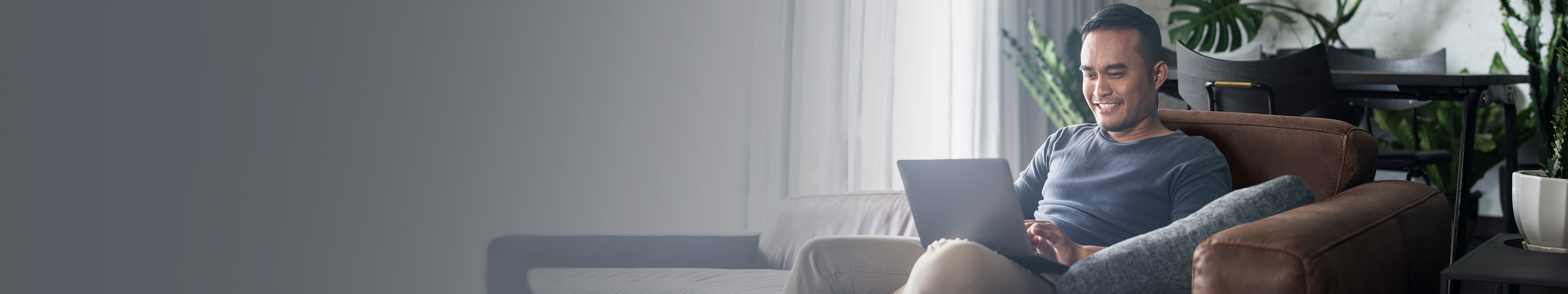 Guy on couch, working on laptop. 