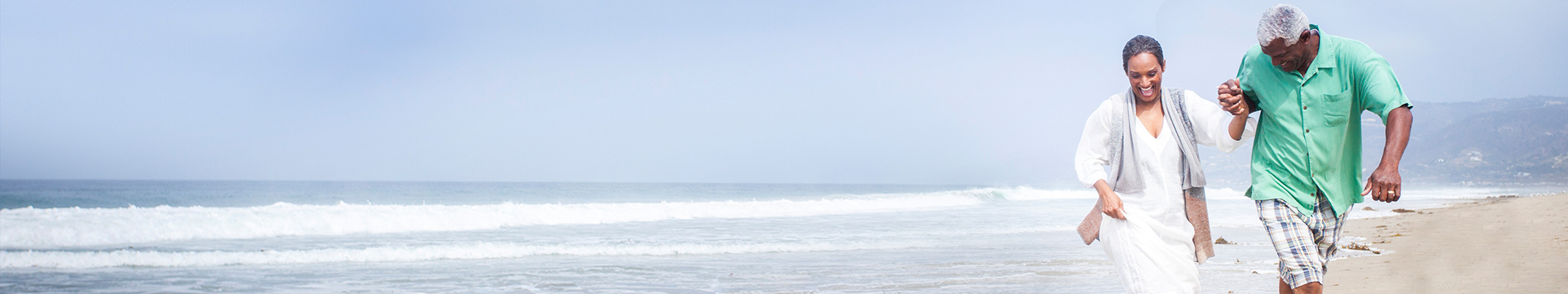 Una pareja mayor camina por la playa.