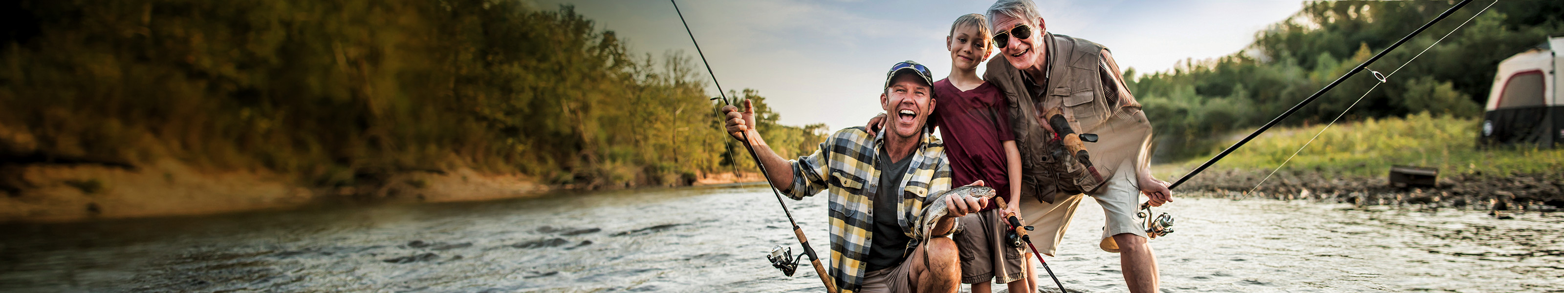 Abuelo, padre e hijo pescando en un arroyo.