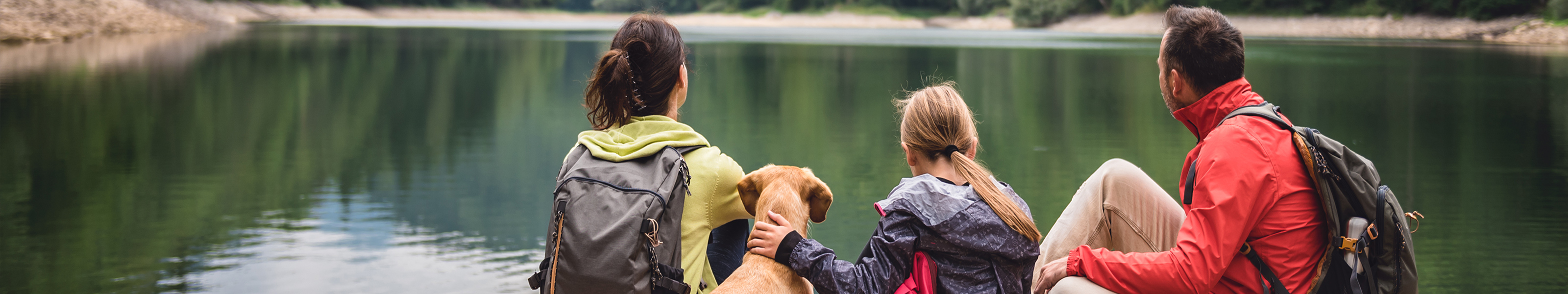 A distinct client experience. mom dad daughter family at lake with dog