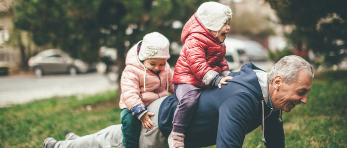 grandfather with grandchildren playing in the yard
