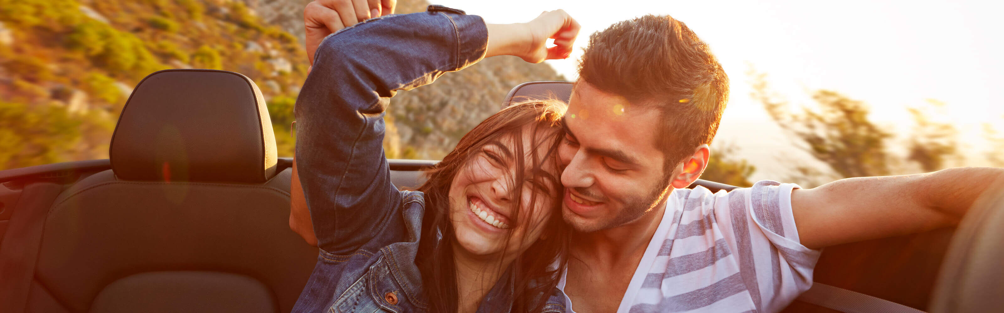 Man and woman sitting in car smiling