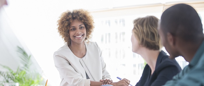 woman smiling in meeting with man and woman